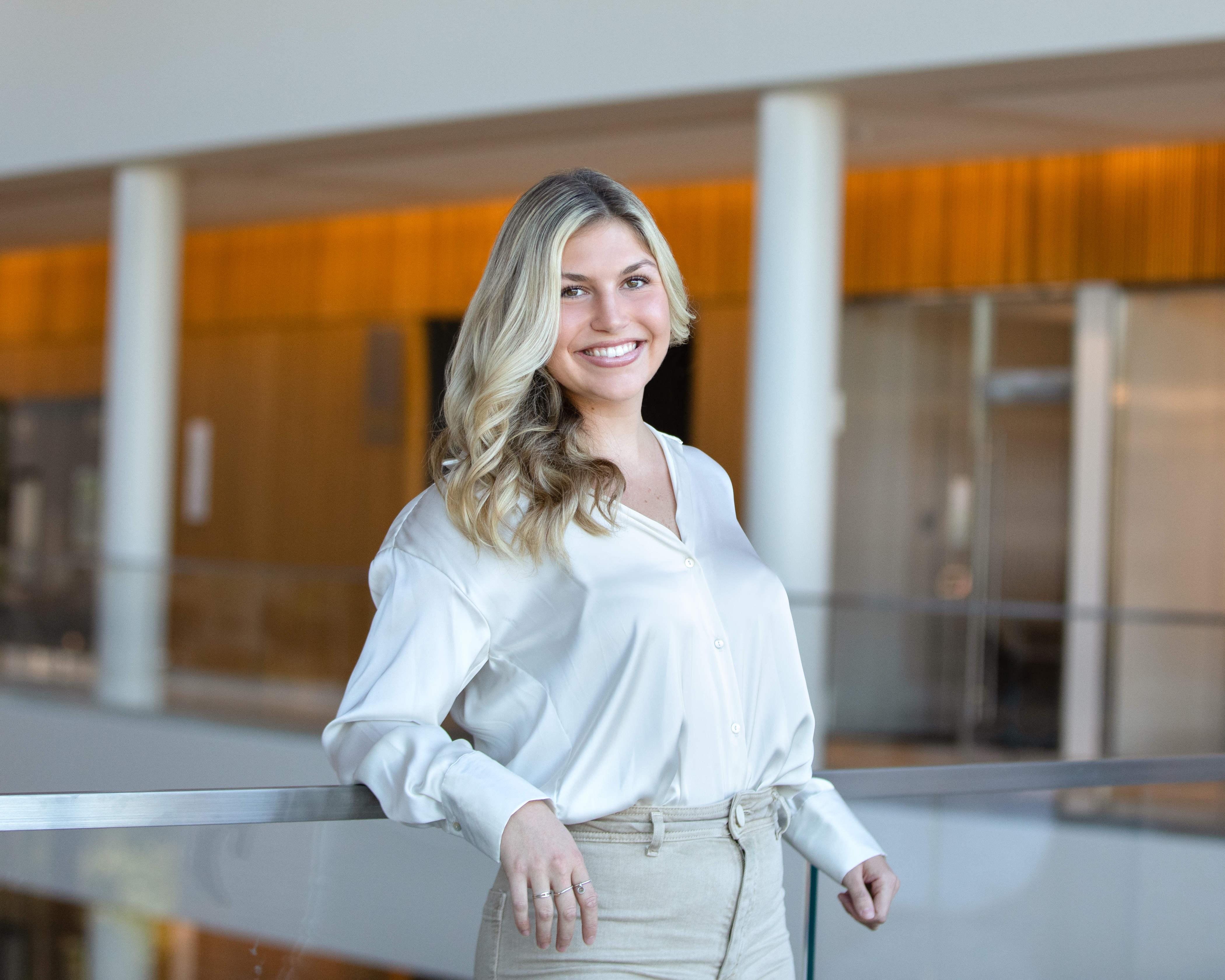 A picture of Emma Hochstein smiling while leaning against a railing